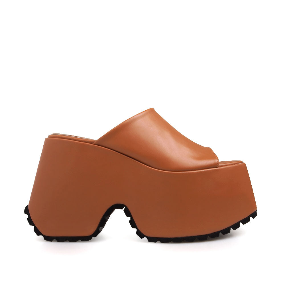 Slip-on tan colored platforms with an open toe - side view