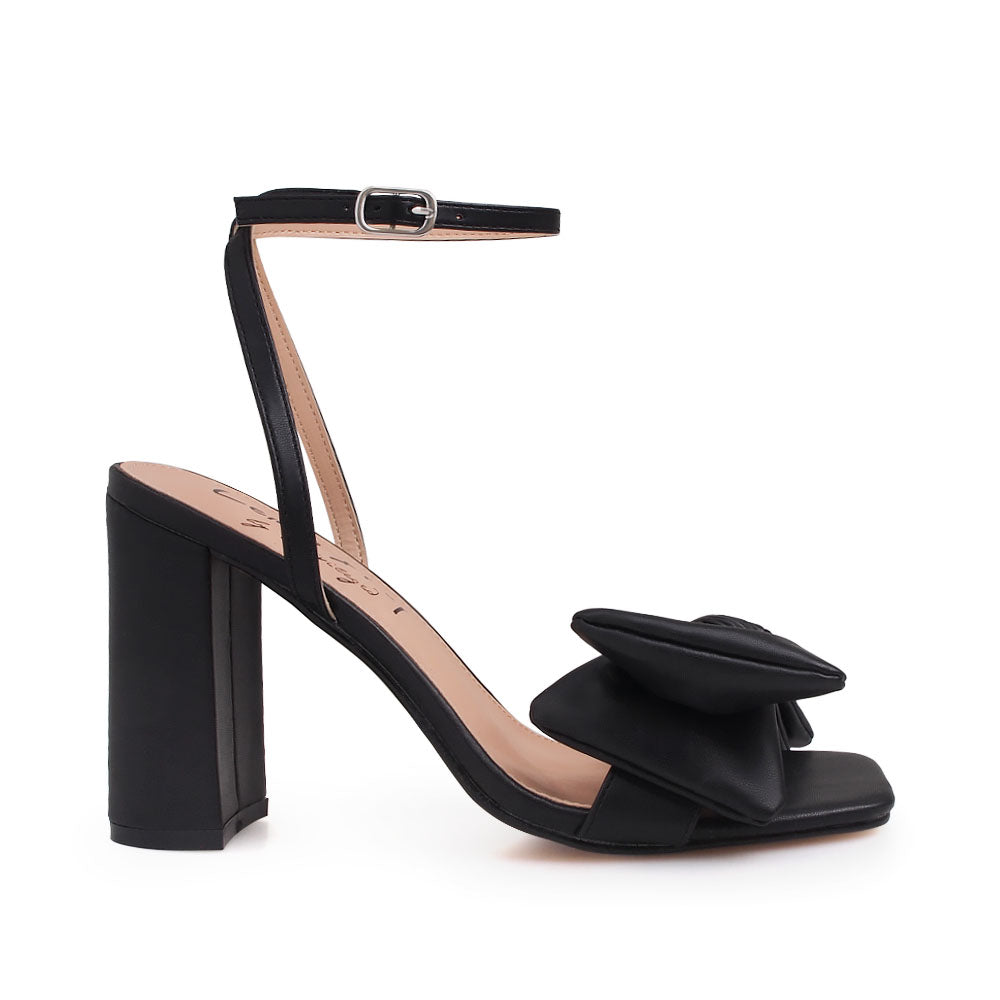 Black heels with bow design upper and ankle buckle clasp - side view