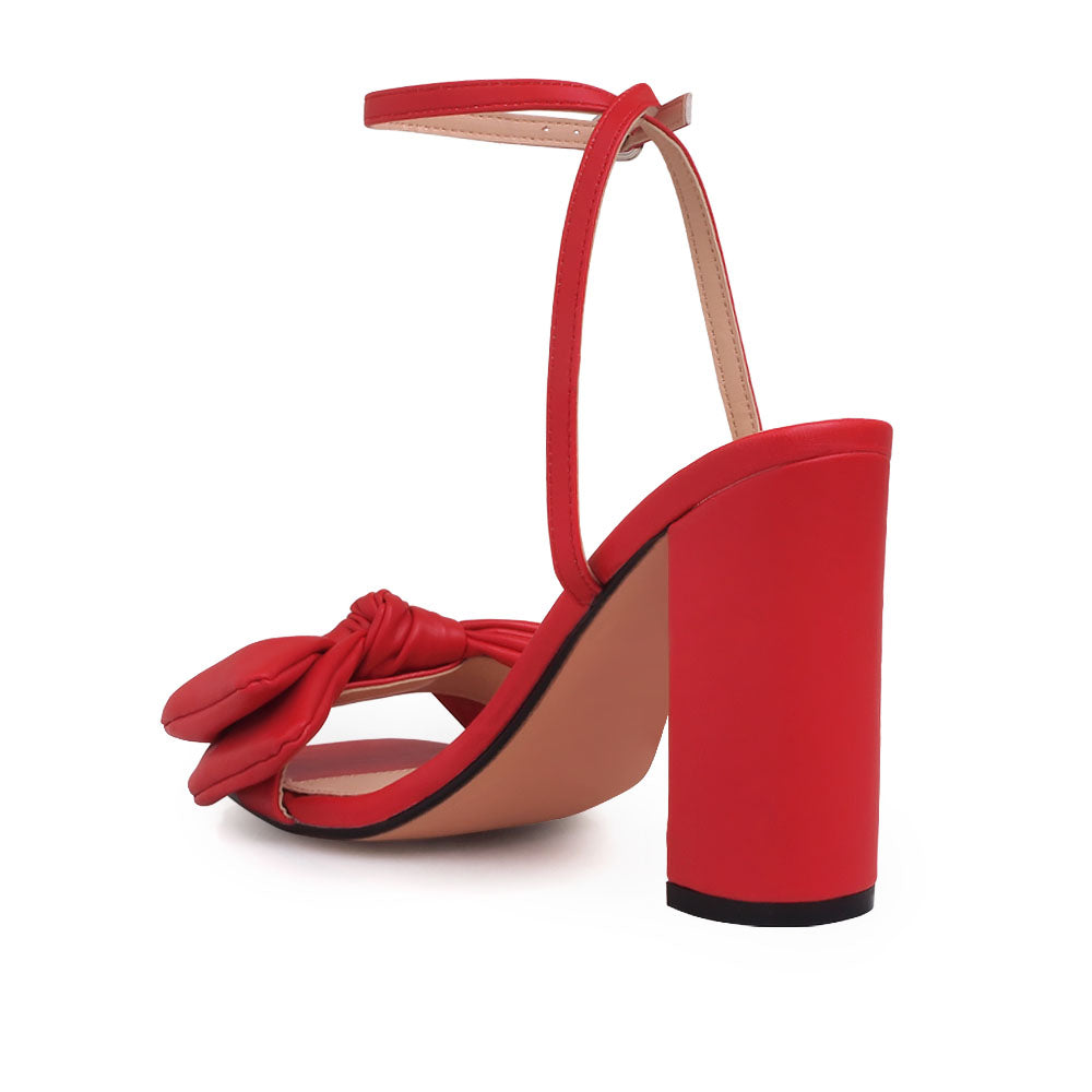 Red heels with bow design upper and ankle buckle clasp - back view