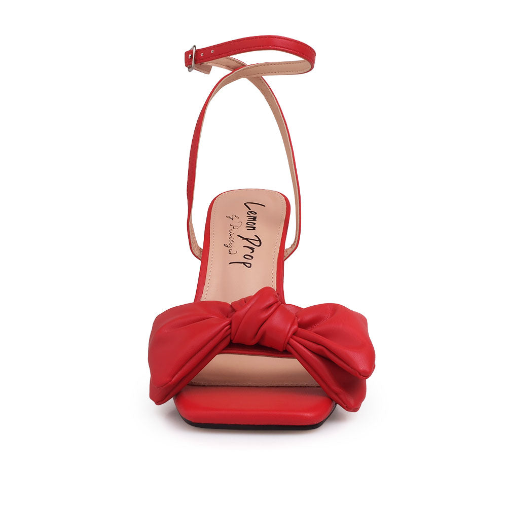 Red heels with bow design upper and ankle buckle clasp - front view