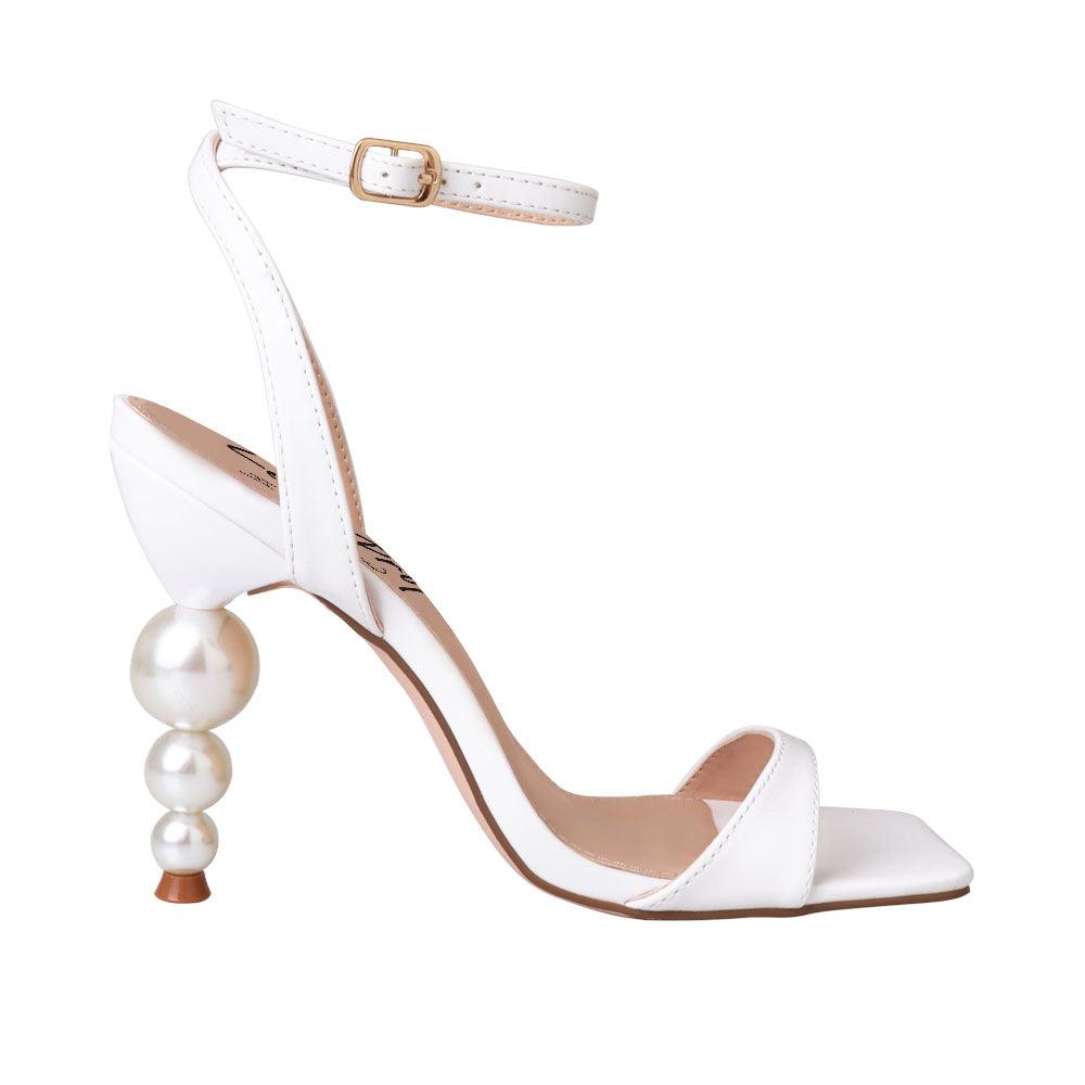 White colored women heels with ankle buckle closure and three tiered pearl heel-side view