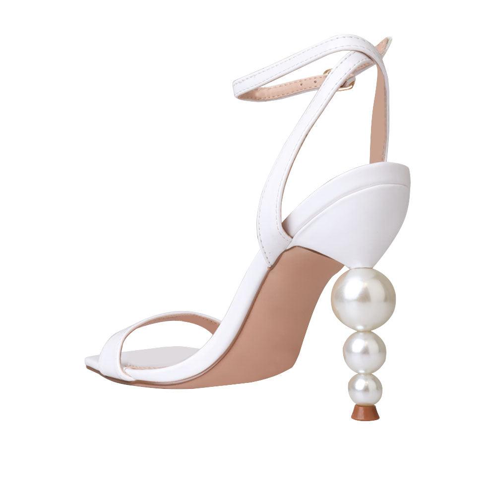 White colored women heels with ankle buckle closure and three tiered pearl heel-posterior view