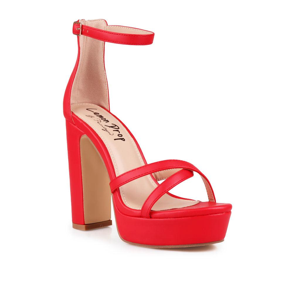 Red platform heels with ankle buckle closure and open toe design - corner view
