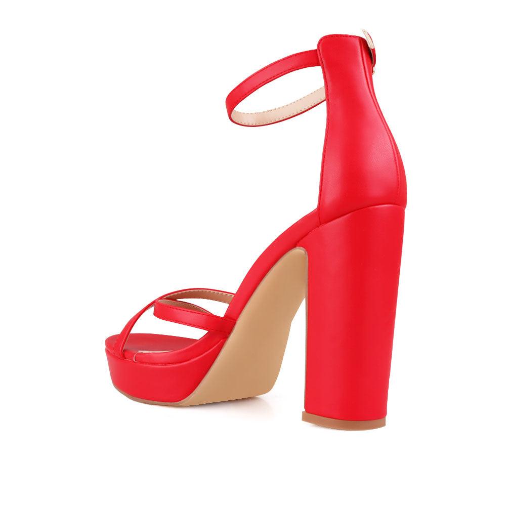 Red platform heels with ankle buckle closure and open toe design - back view