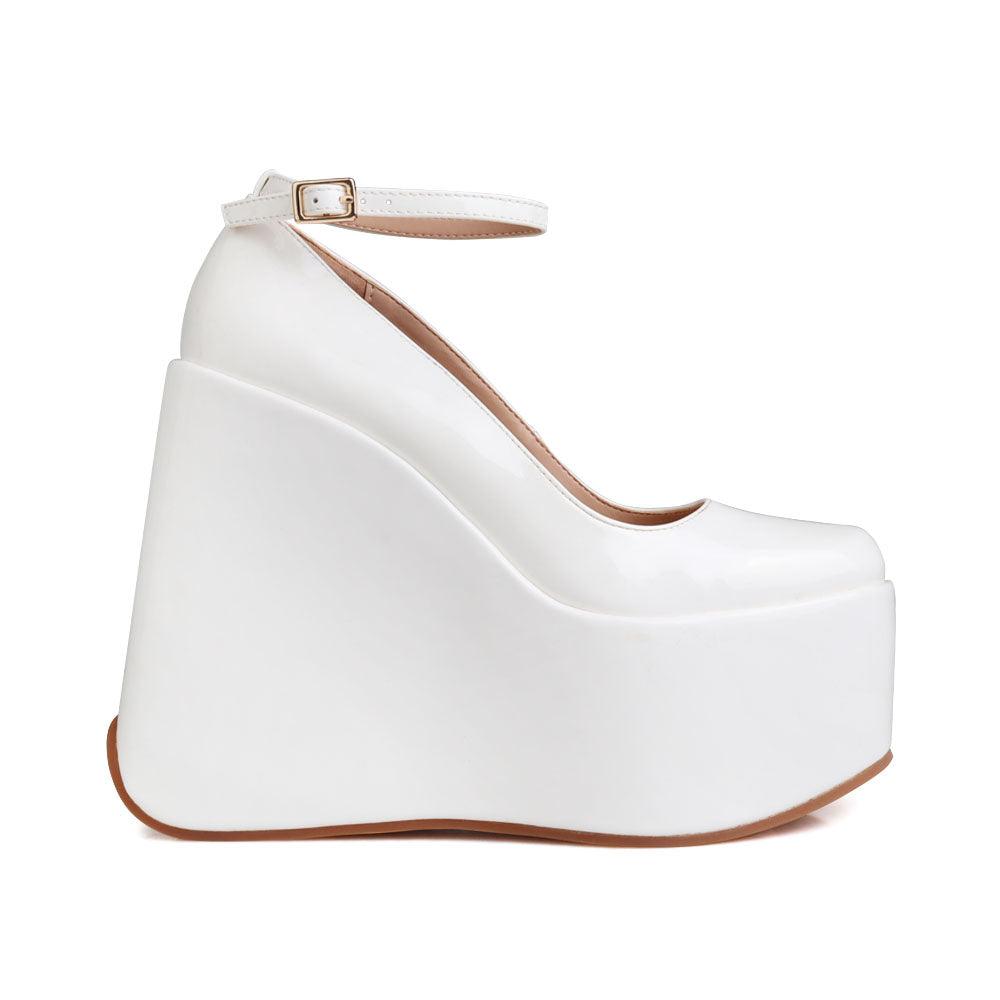 White colored platform boots with an ankle buckle closure