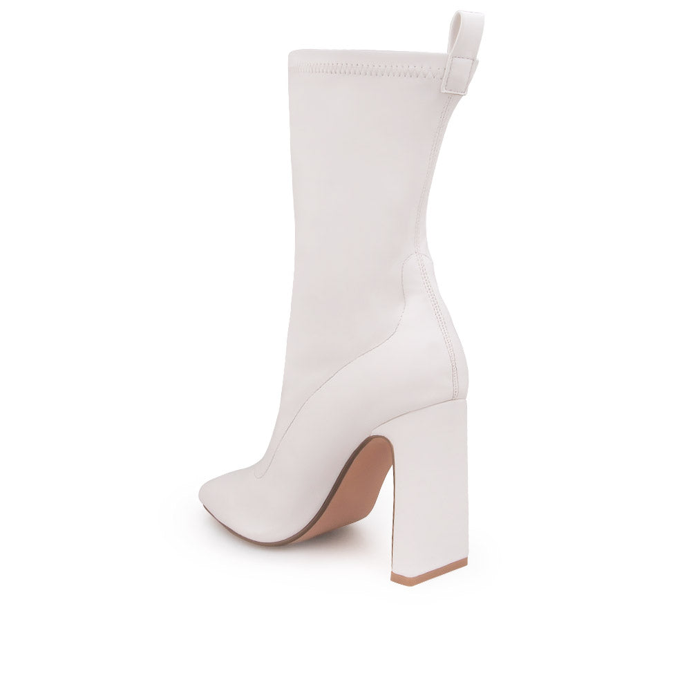 White ankle-high heels with a pointed toe and zip closure - back view