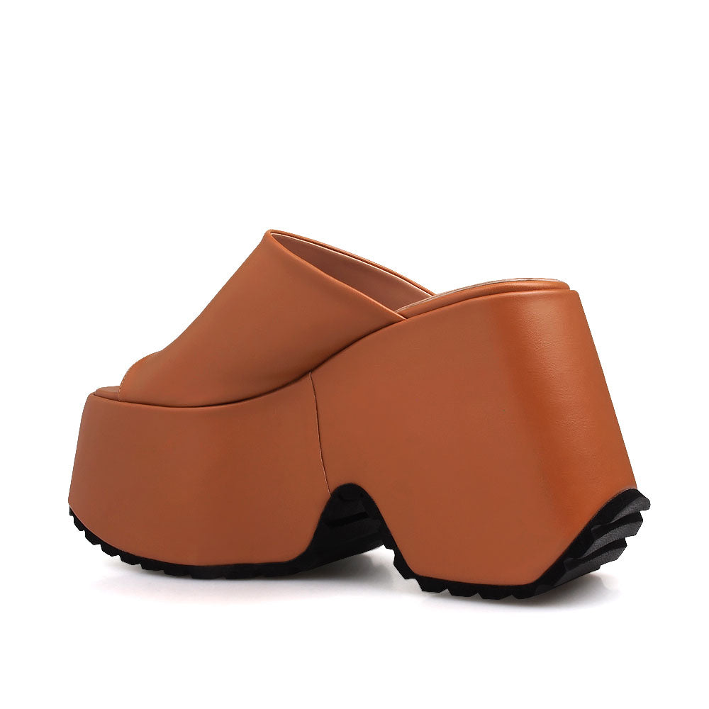 Slip-on tan colored platforms with an open toe - back view