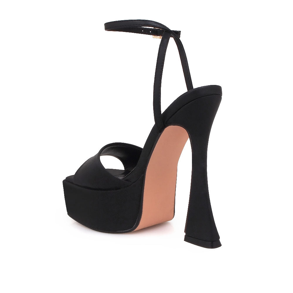 Black platform heels with open toe and ankle buckle closure - back view