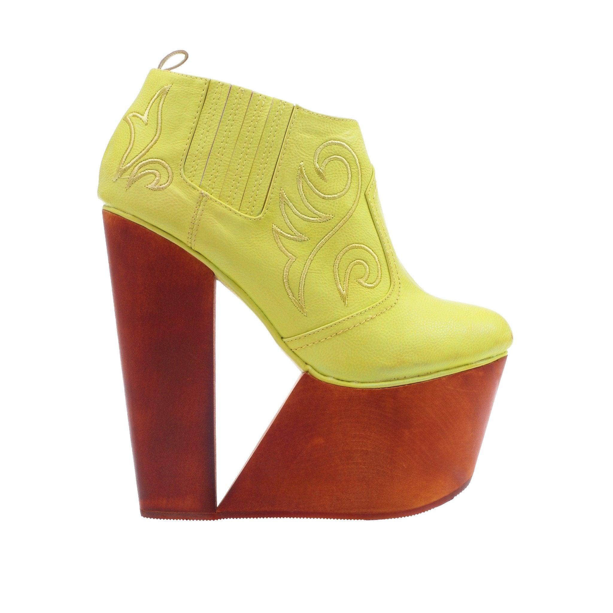 Wooden wedge base slip on boots in neon yellow upper.