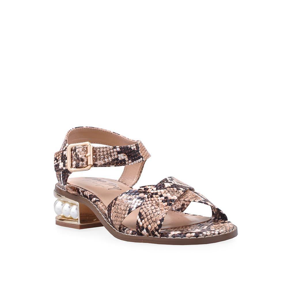 Women's tan-colored flat shoes with snake-patterned straps and a large pearl on the heel-corner view