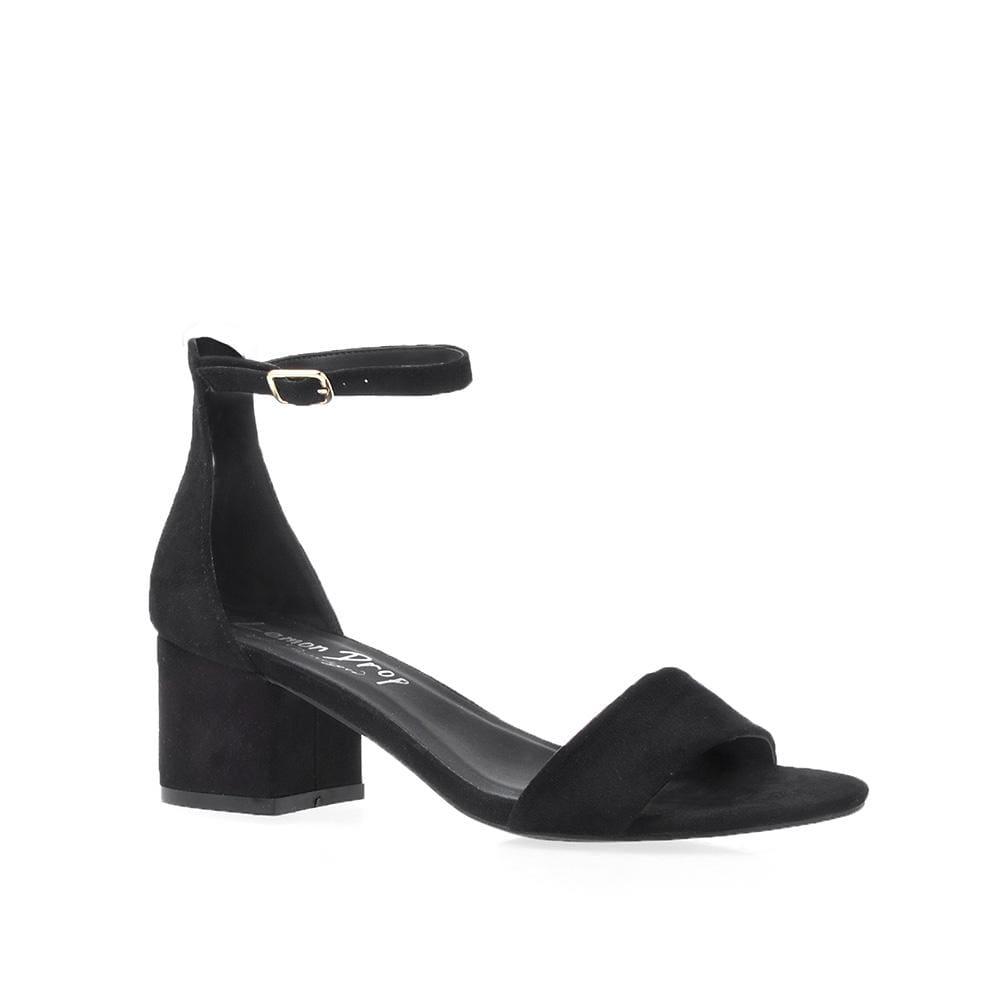 Plain black heel flats with a buckle ankle closure and a strapped open toe-corner view