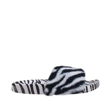 Flat slippers in black and white-color with faux fur top and an open front.