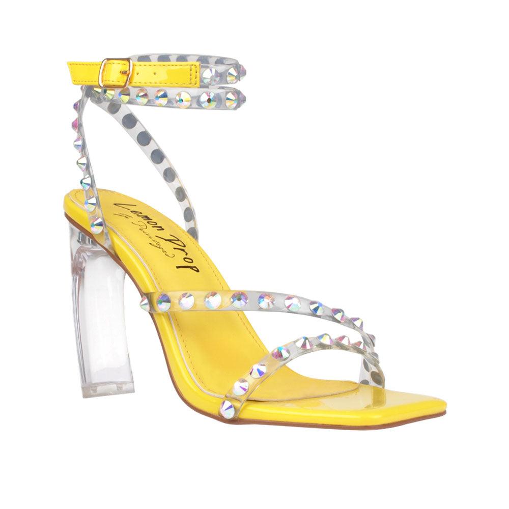 Ankle-strap heels in a bright yellow color with an open toe and buckle - corner view