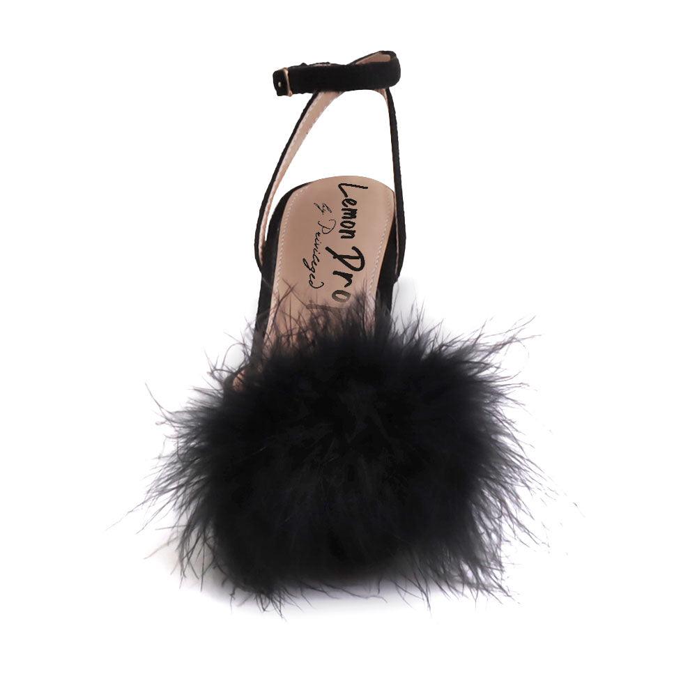 Black-colored women's pointed-toe heels with front fur pom upper and ankle buckle closure-front view