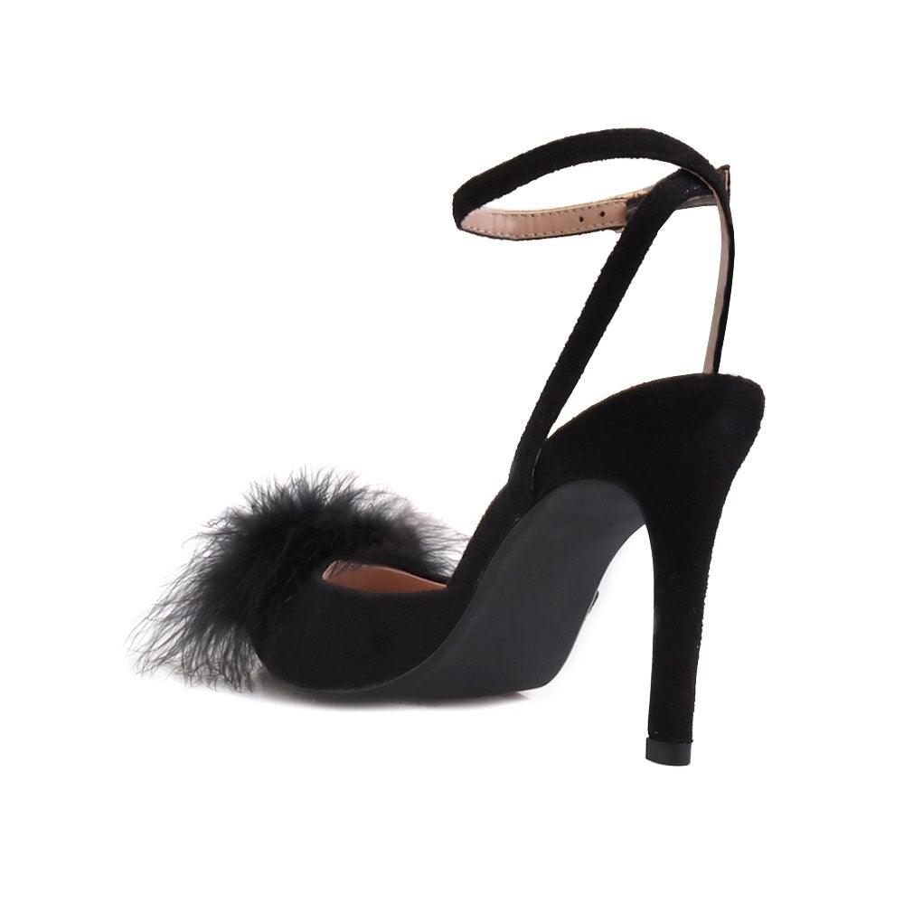 Black-colored women's pointed-toe heels with front fur pom upper and ankle buckle closure-posterior view