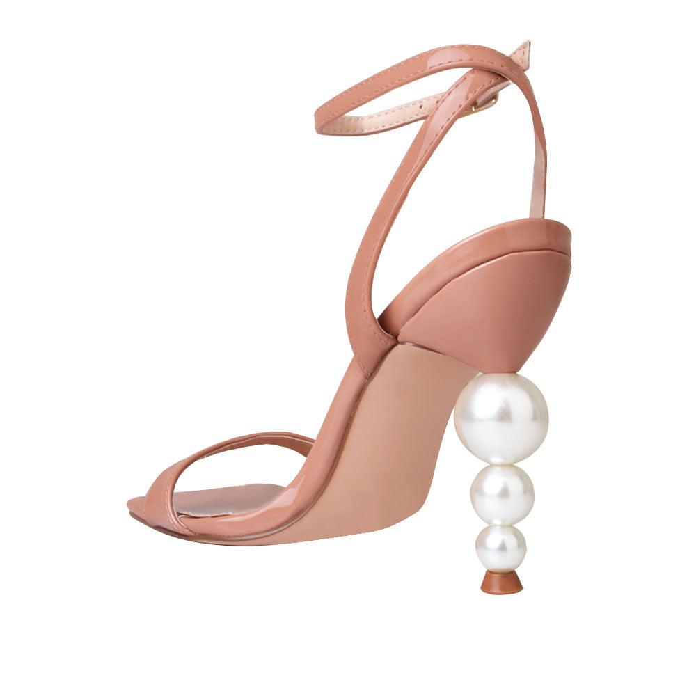 Nude colored women heels with ankle buckle closure and three tiered pearl heel-posterior view