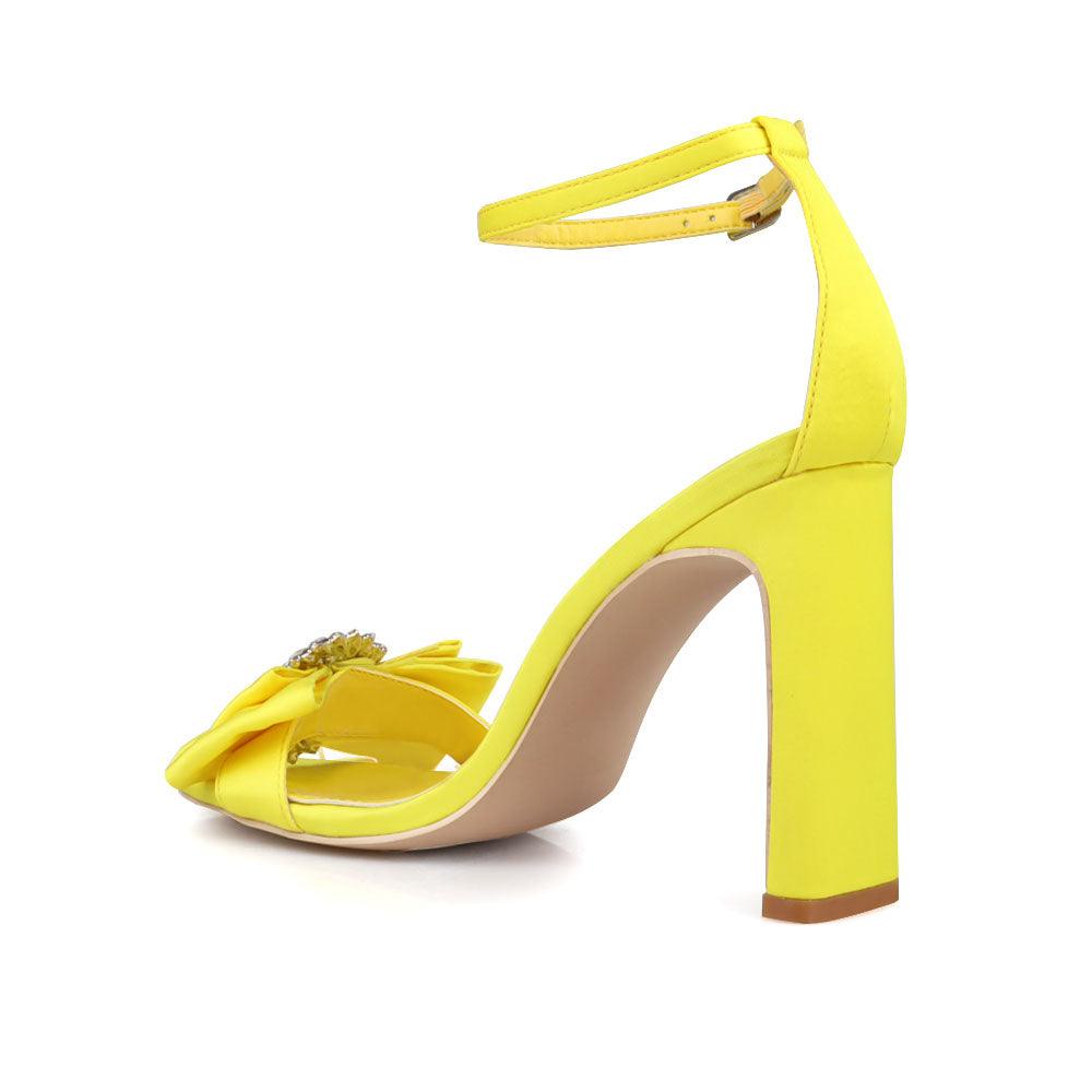 Mustard colored women heels with silver bow on upper-posterior view