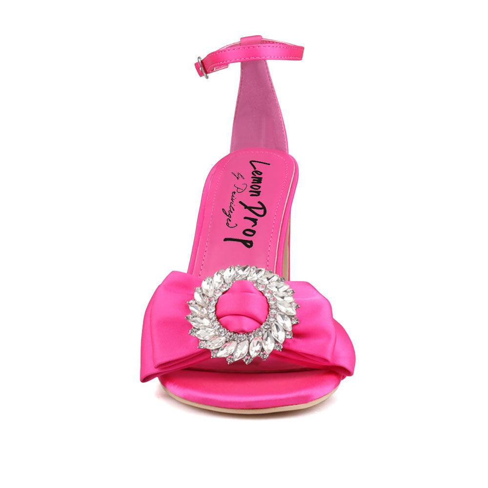 Pink colored women heels with silver bow on upper-front view