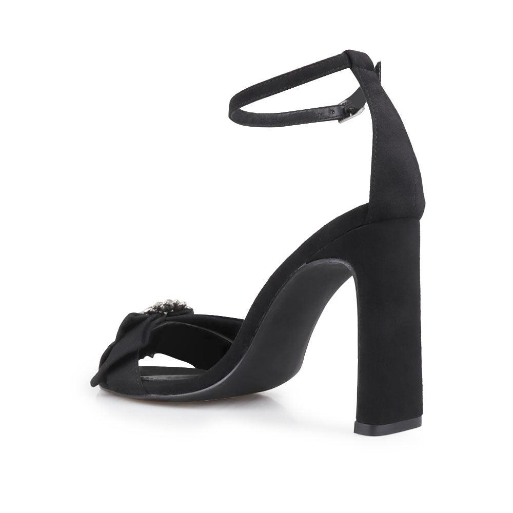 Black colored women heels with silver bow on upper-posterior view