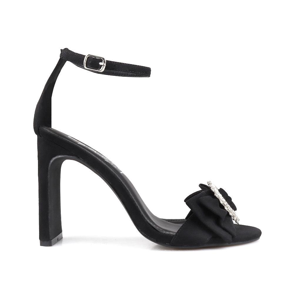 Black colored women heels with silver bow on upper-side view