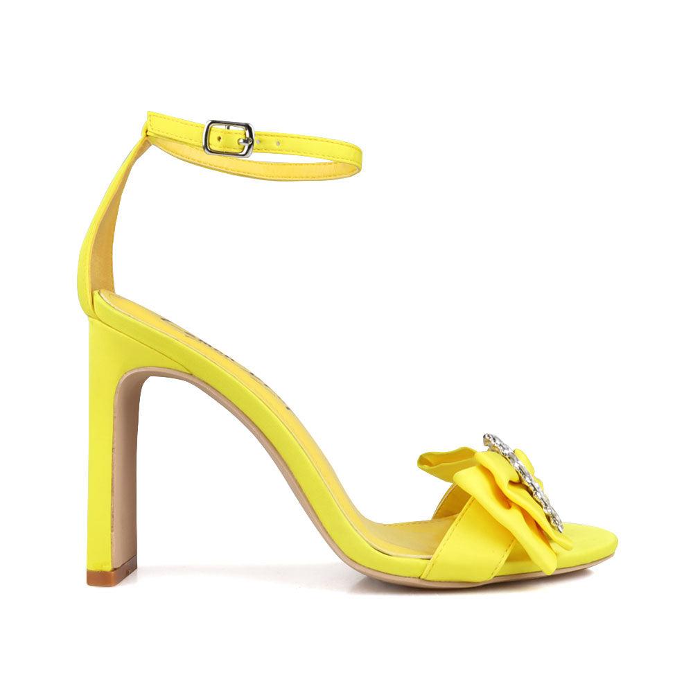 Mustard colored women heels with silver bow on upper-side view