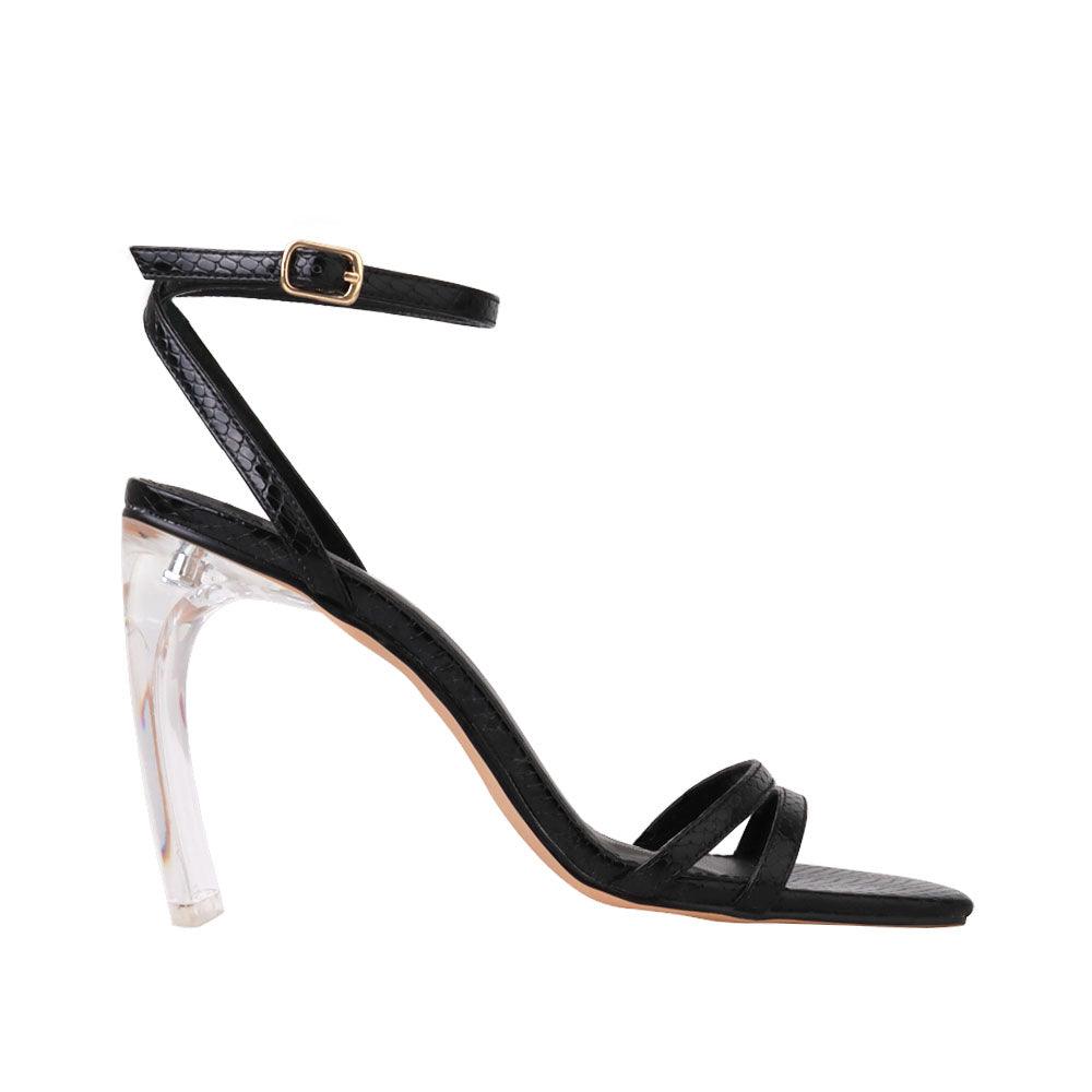 Women's clear heels with black upper and ankle buckle strap.