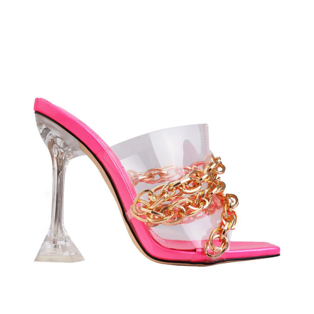 Transparent fuchsia heels with slip-on style, golden chain accent, and clear top.