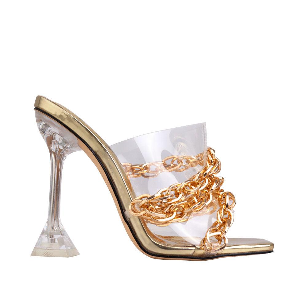 Golden colored translucent heels with slip on design, chain accent and clear upper