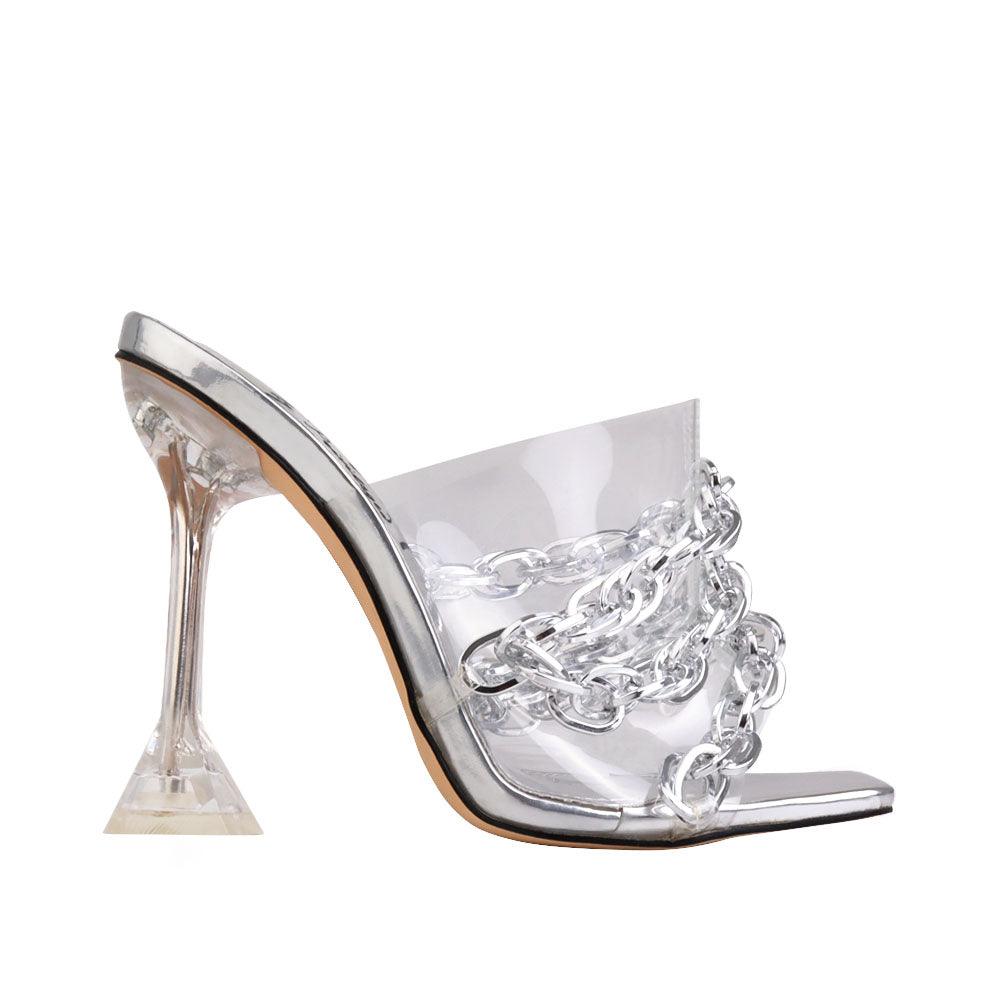 Translucent silver heels with slip-on design, chain accent, and clear top.