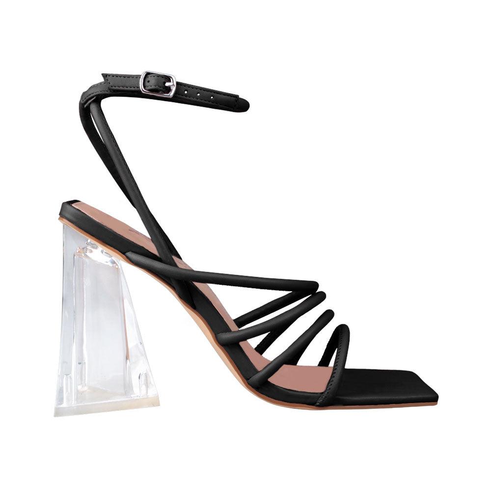 Translucent heels with black strappy sandal design and an ankle buck closure.