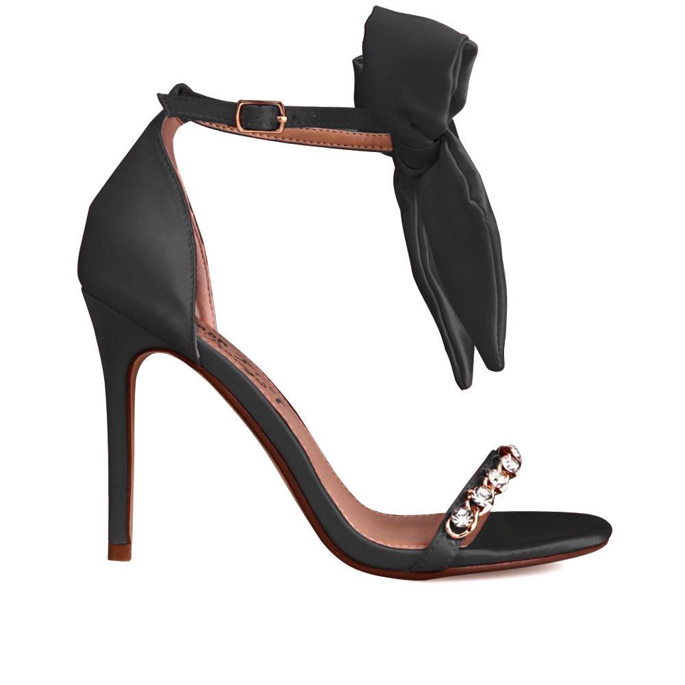 Black heels with gem-encrusted strap and ankle buckle clasp with bow style.