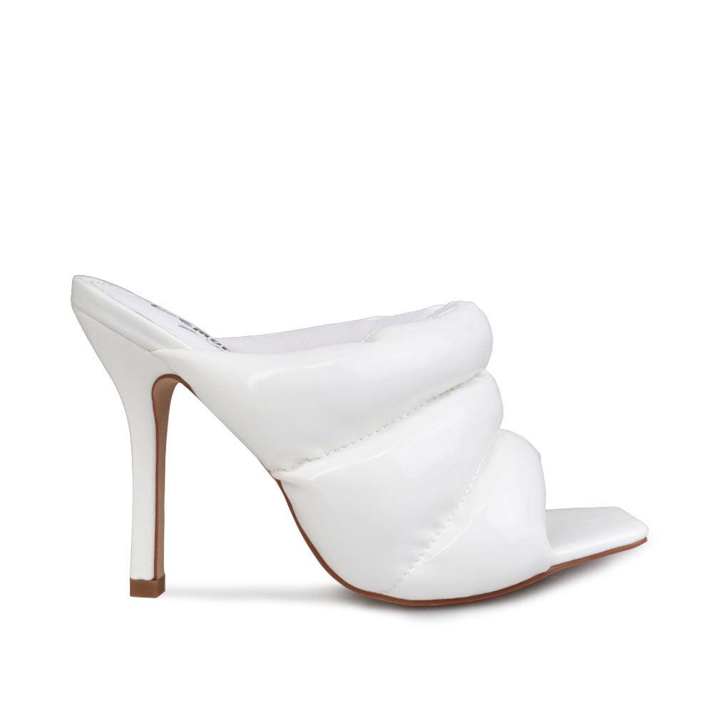 Women's white leather heels with slip-on design and an open toe.