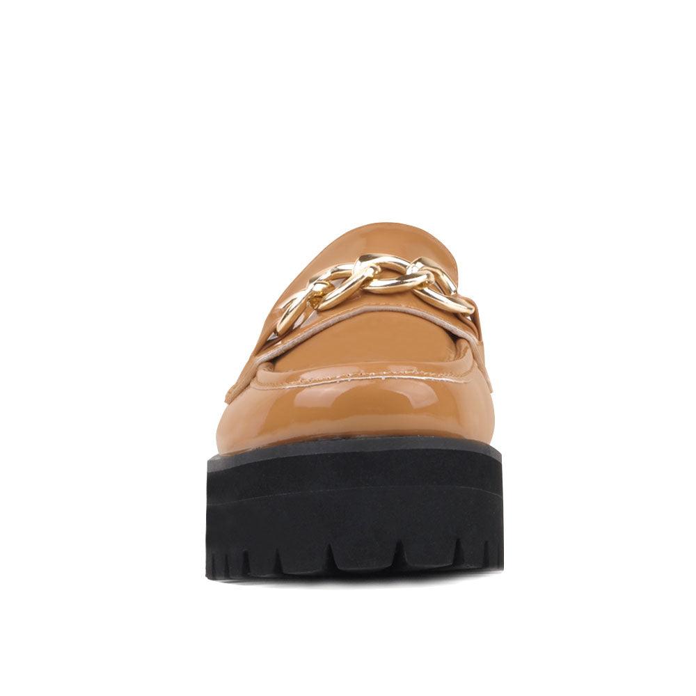 Women's tan-colored leather shoes with metal chain and thick black bottom-front view