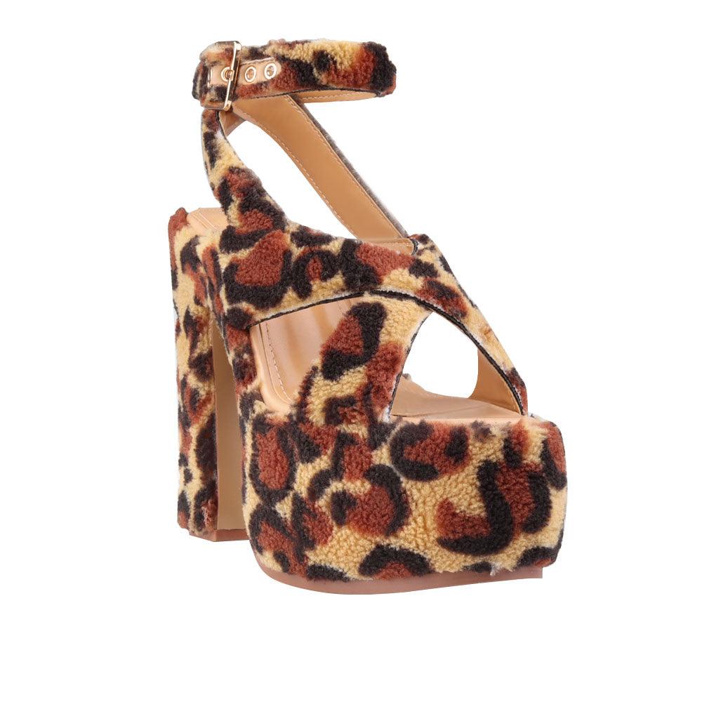 Upper platform crossed strap block heels with ankle buckle closure in leopard patterned shearling-corner view