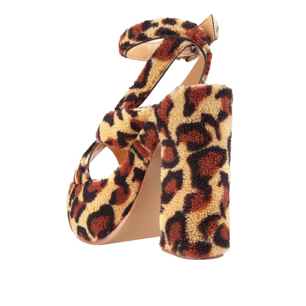 Upper platform crossed strap block heels with ankle buckle closure in leopard patterned shearling-posterior view