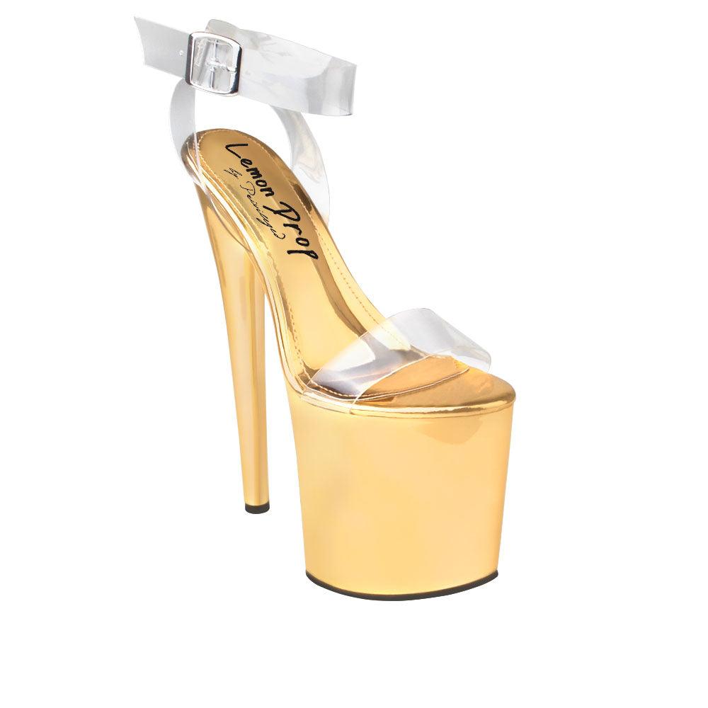 Women's golden-colored high heel platform shoes with an upper clear ankle buckle closure and strap-corner view