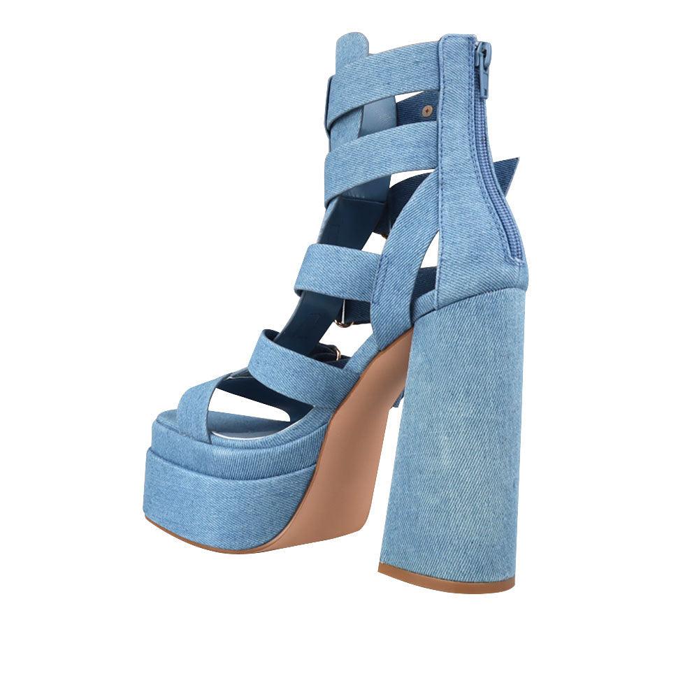 Denim-colored women's platform shoe heels with decorative buckle straps and back zipper-posterior view