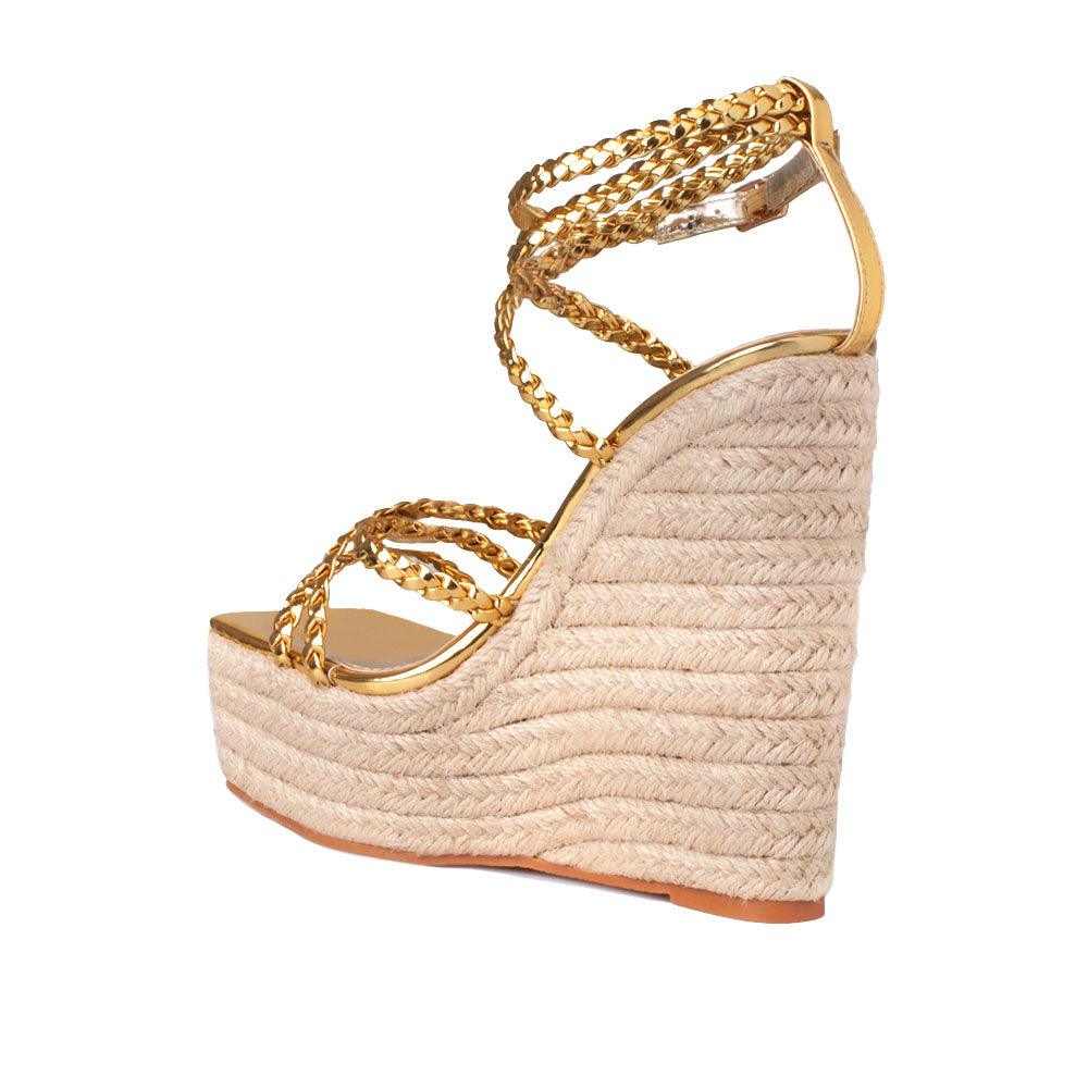 women's tan-colored wedge heels with golden upper strap and ankle buckle clasp-posterior view