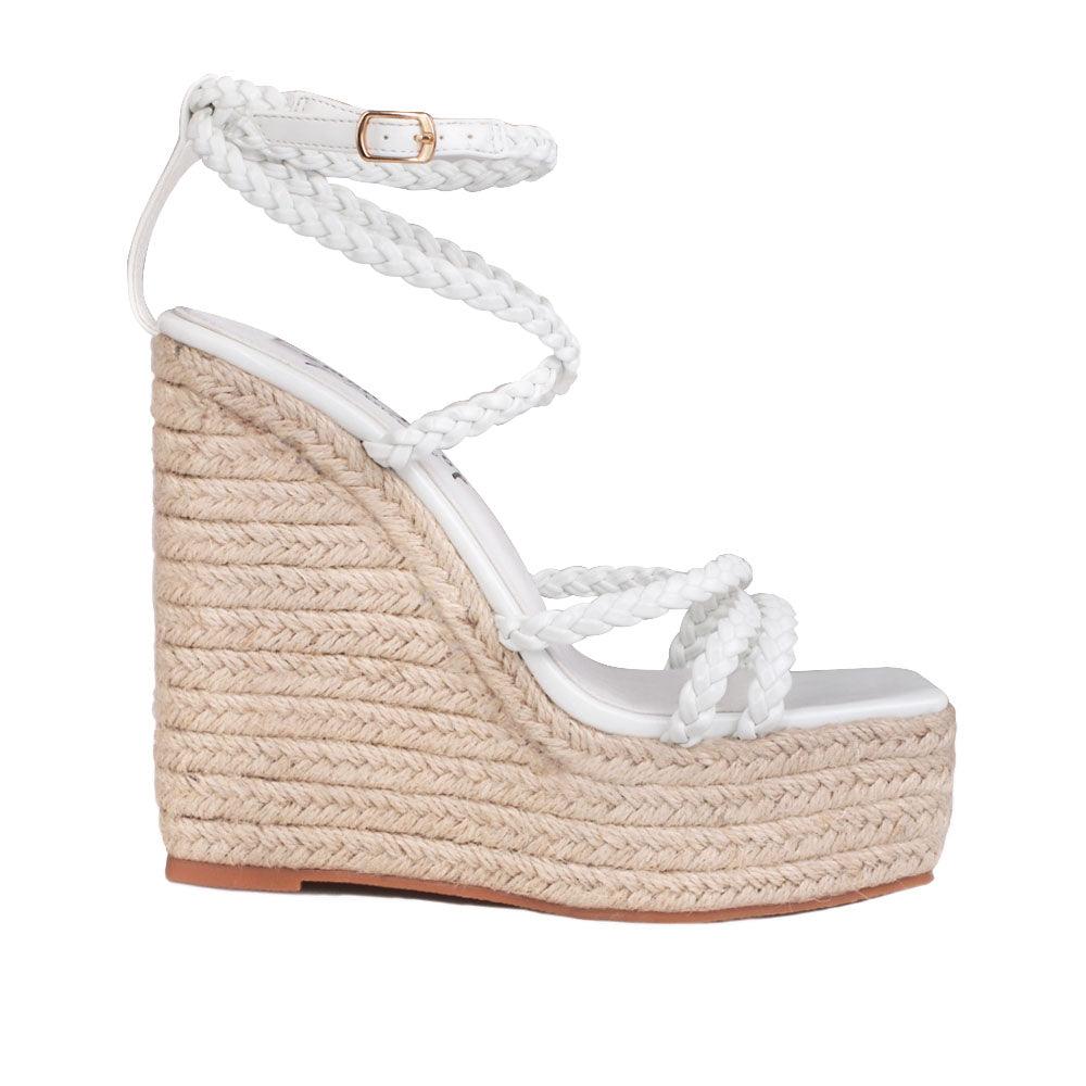 Ladies' tan-colored wedge heels with a white upper strap and an ankle buckle clasp-side view