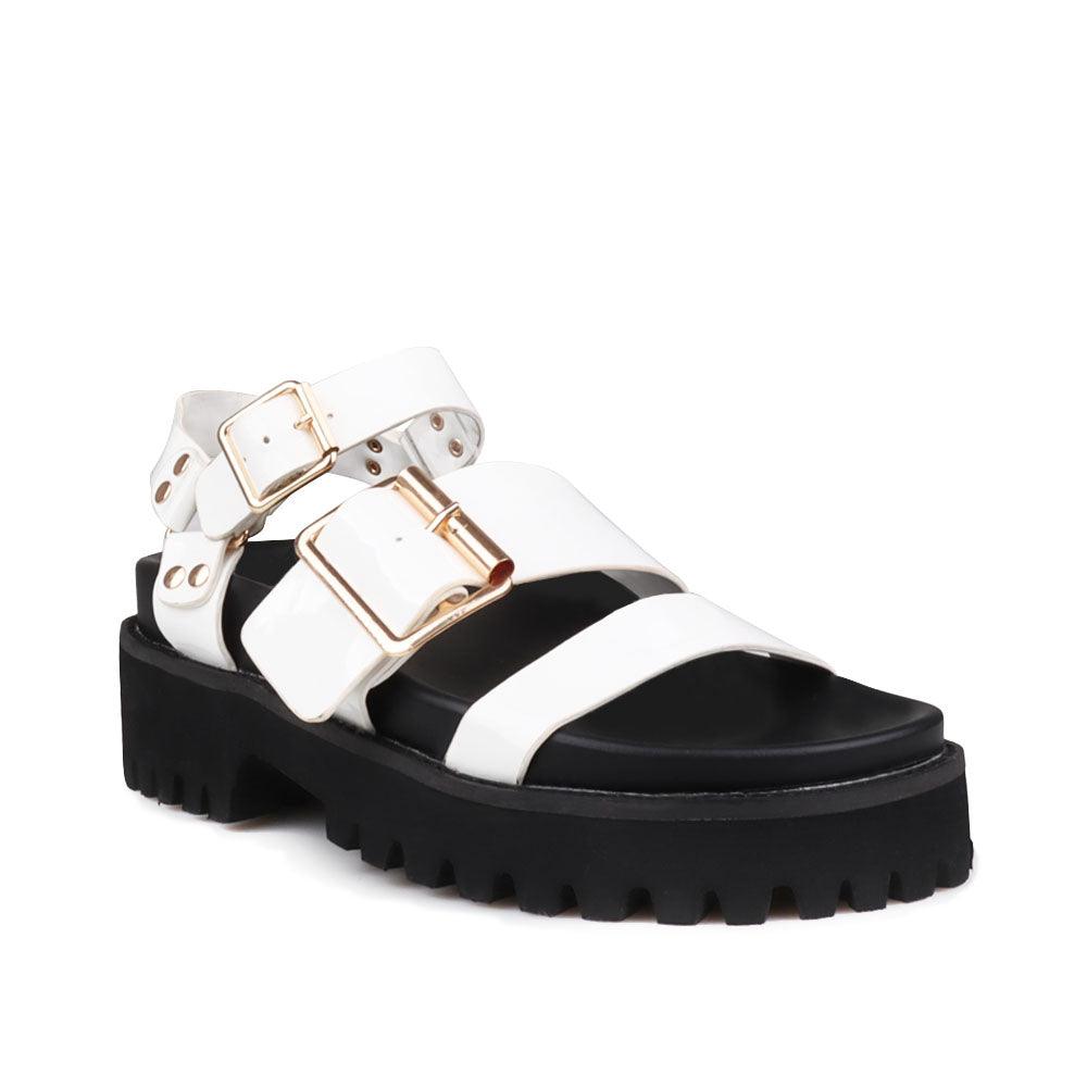 Women's white platform with buckle straps, ankle buckle closure, and black bottom-corner view