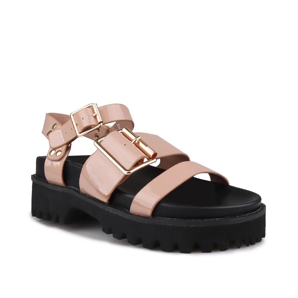 Nude-colored women's platform sandals with ankle buckle closure and buckle strap design upper-corner view