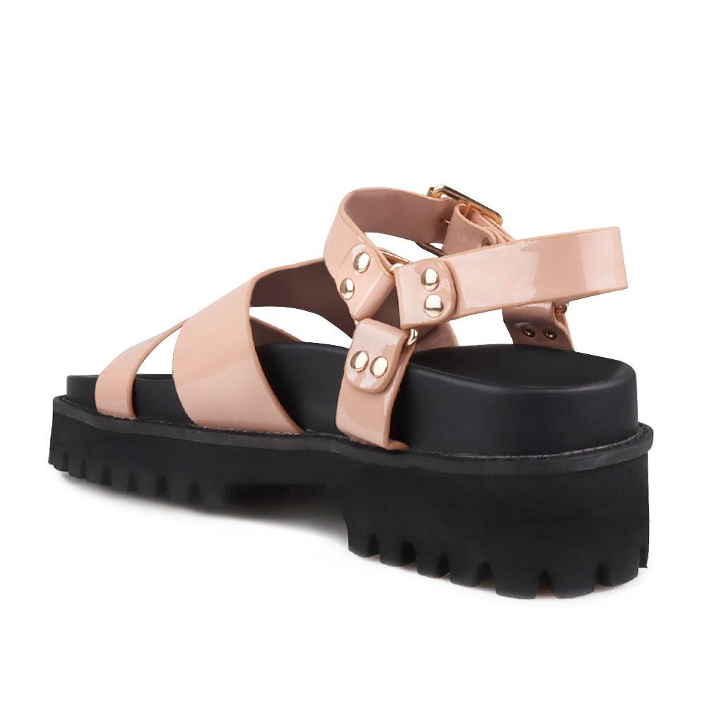 Nude-colored women's platform sandals with ankle buckle closure and buckle strap design upper-posterior view