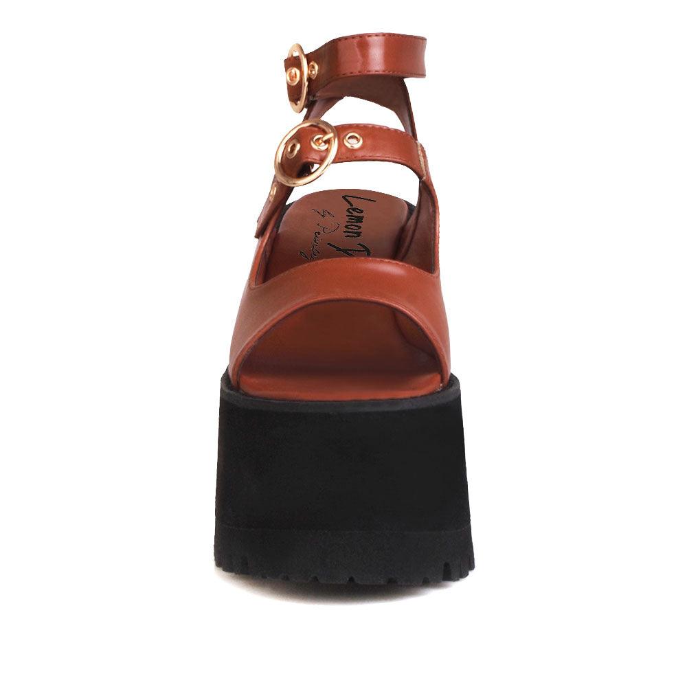 Brown women platforms with black bottom and double ankle buckles-front view