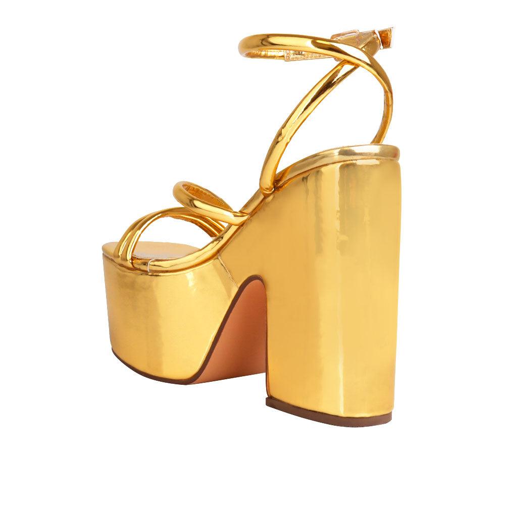 Golden colored women platform heels with ankle buckle closure-posterior view