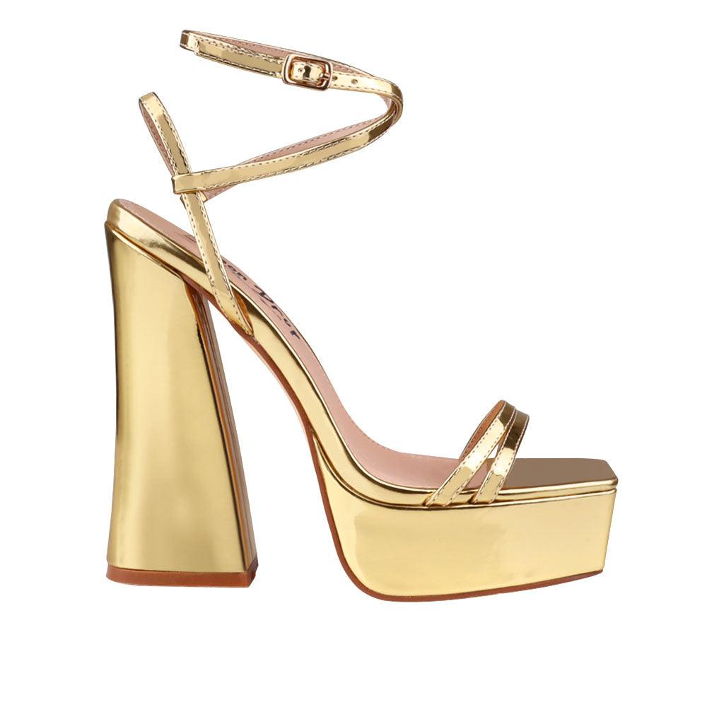 Golden metallic platform heels with ankle buckle closure.