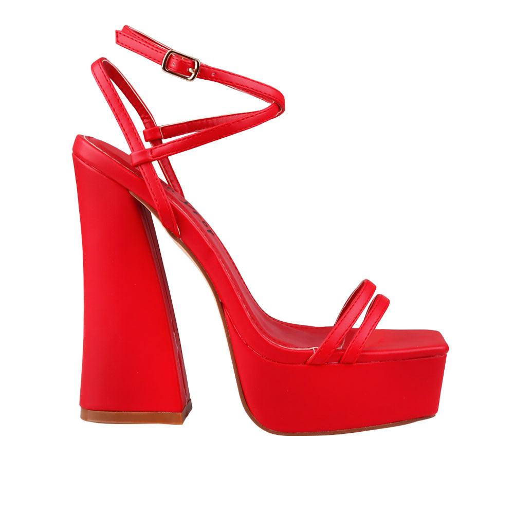 Red platform heels with ankle buckle clasp.