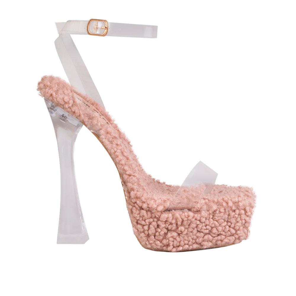 Nude colored shearling upper and platform heels with a translucent ankle buckle clasp