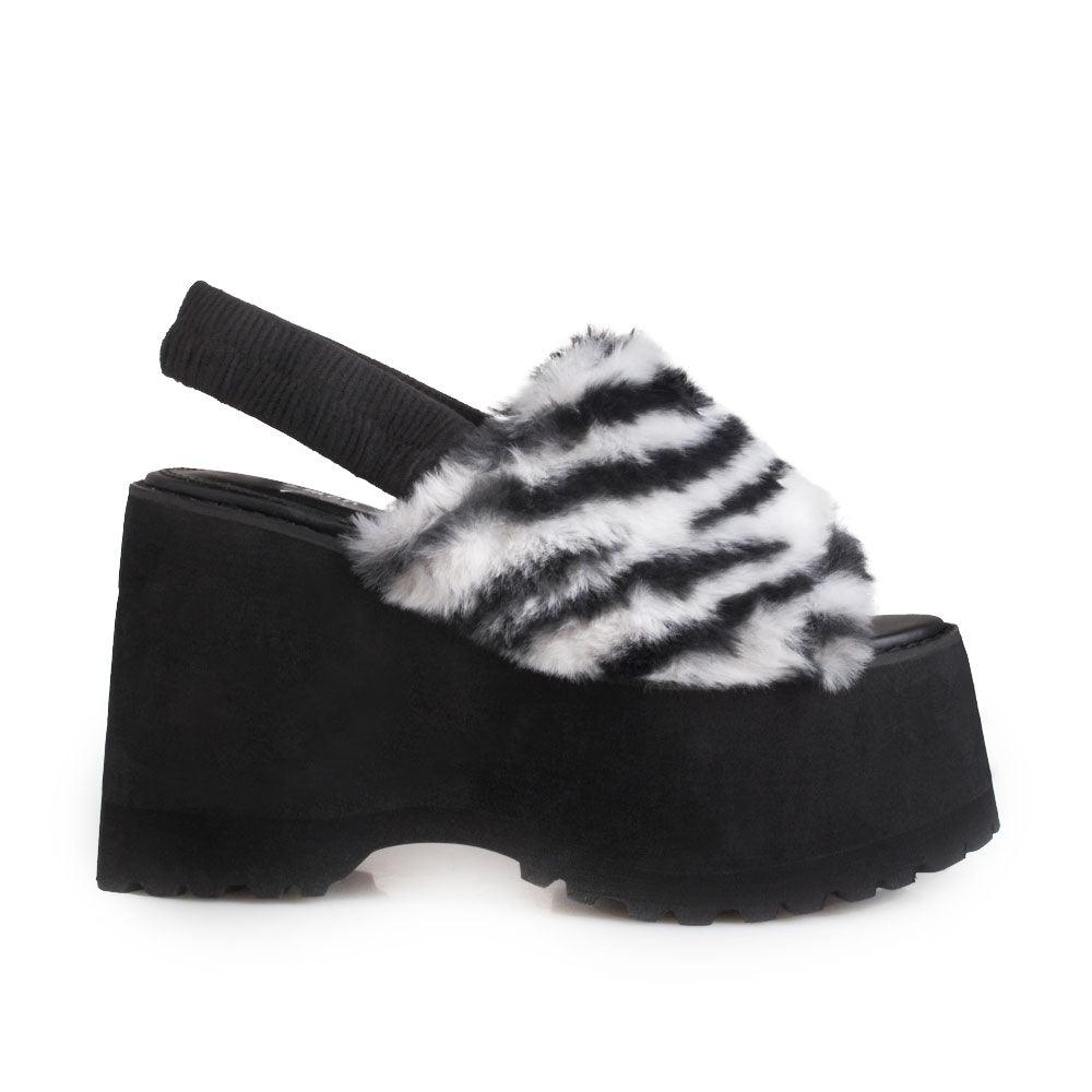 Black and white colored platforms with fur upper and slip on design