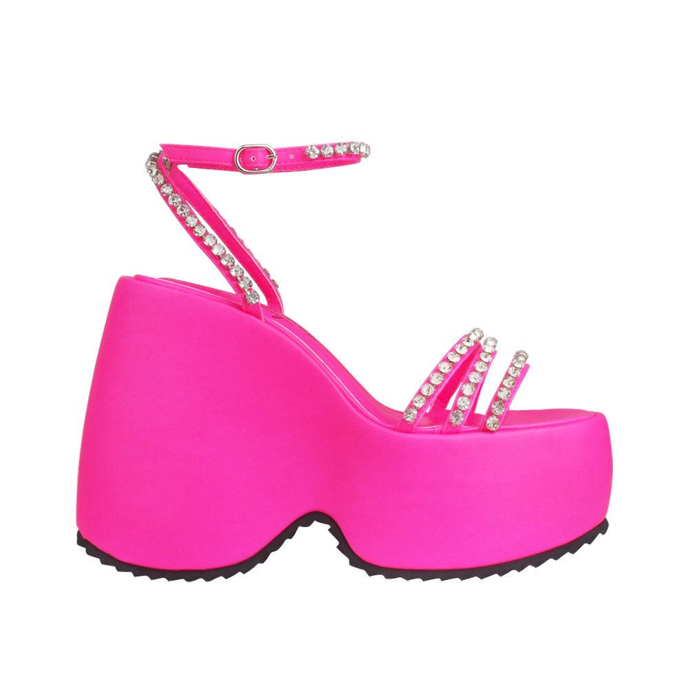 Platforms in pink with ankle buckle clasp and multiple straps decorated with gems 