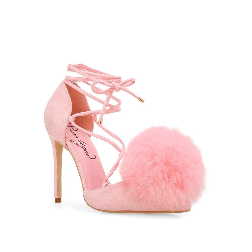 Women's pink-colored high heel pumps with faux fur pom on top and ankle wrap lace up-corner view